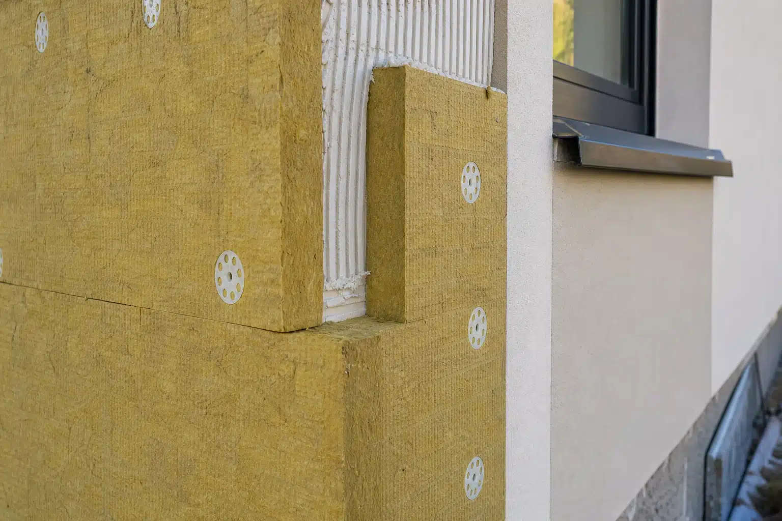 Panneaux d'isolation jaune fixés sur façade près d'une fenêtre